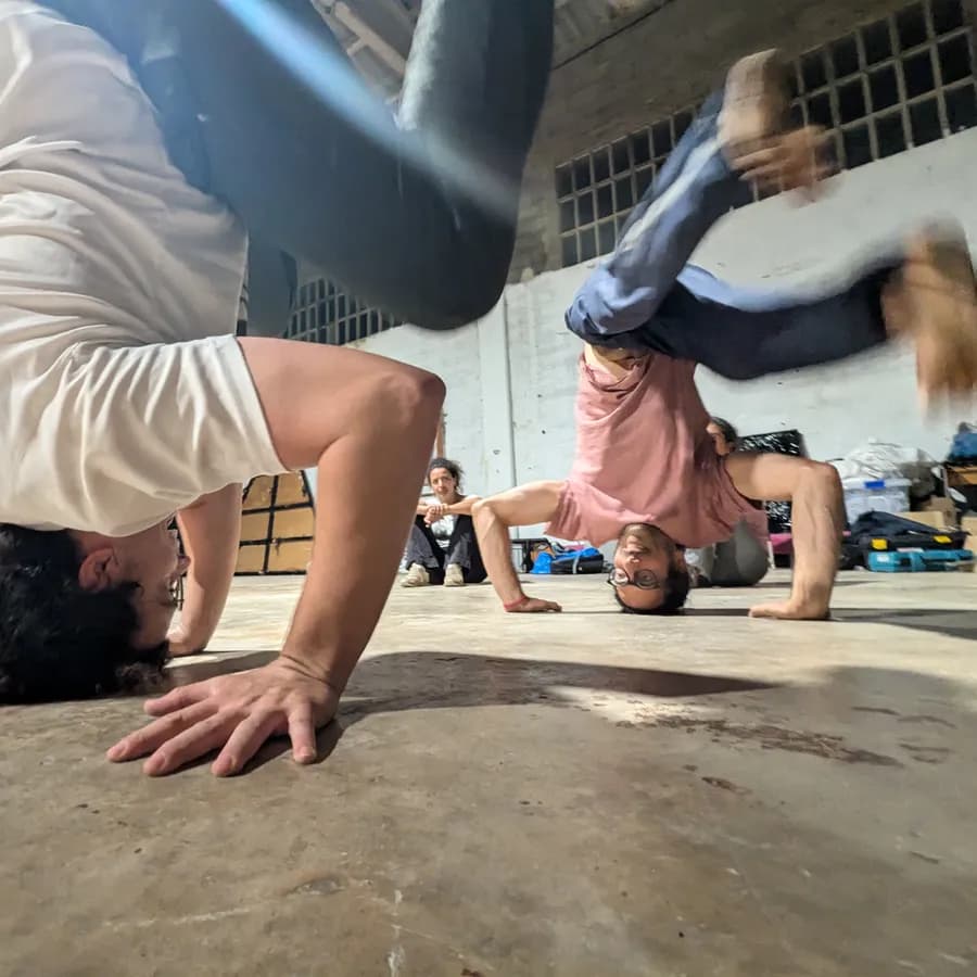 Dues persones de cap per avall, fent la vertical durant l’entrenament.